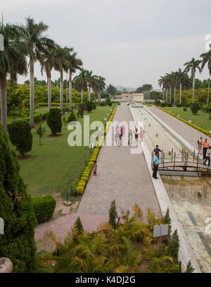 Giardini Pinjore (Yadavindra Gardens) costruito per le concubine del righello. Il palazzo si riflette nell'acqua. Donne indù a piedi sulle terrazze. Foto Stock