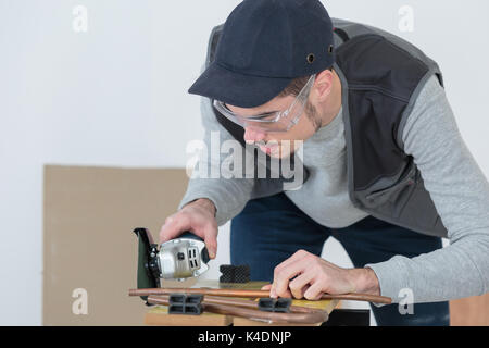 Bello il carpentiere in occhiali protettivi Foto Stock