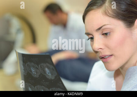 Medico donna strettamente esaminando i raggi x al torace Foto Stock