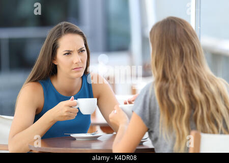 Due gravi amici avente una conversazione seduto in un bar terrazza Foto Stock