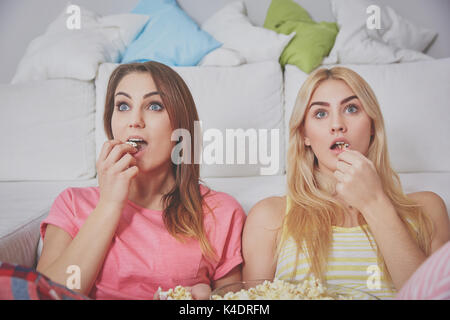 Ritratto di due donne sconvolto guardando film mangiare popcorn. Foto Stock