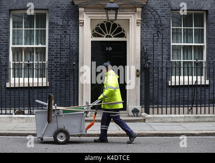 Un pulitore di via al di fuori 10 Downing Street, Londra, precedendo la partenza di Theresa Maggio per il primo ministro di domande. Foto Stock