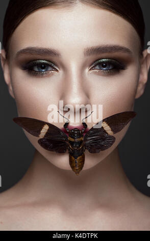 Ritratto di bella ragazza con colorati per il make-up e cicala. Bellezza viso. Foto scattata in studio. Foto Stock