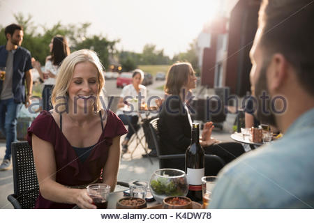 Donna sorridente bere il vino con il mio ragazzo a sidewalk cafe