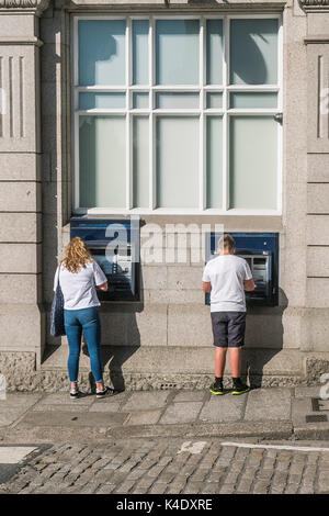 Atm - i clienti che utilizzano atm nel centro della citta'. Foto Stock