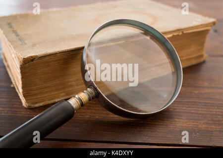 Lente di ingrandimento e vecchio libro Foto Stock