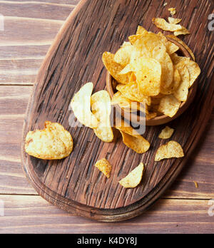 Chip in una ciotola di legno sul tavolo di legno, fuoco selettivo Foto Stock