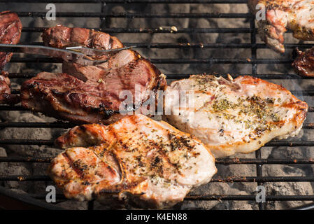 Condito costolette di maiale e bistecca di agnello per la cottura sul carbone di legna per barbecue grill. Foto Stock