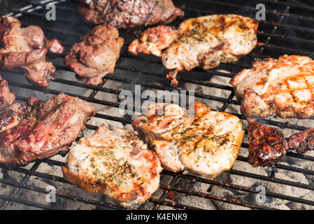 Condito costolette di maiale e bistecca di agnello per la cottura sul carbone di legna per barbecue grill. Foto Stock