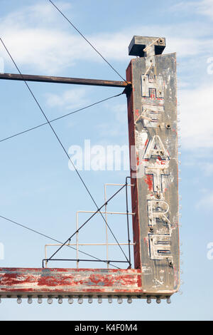 Composizione verticale di metallo teatro neon segno contro il cielo blu Foto Stock