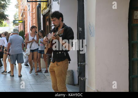 I nativi del luogo nella città di Sibiu, Romania. musicista sta suonando la chitarra su una strada. Foto Stock