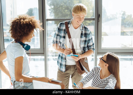 Positivo ai giovani studenti godendo di parlare Foto Stock