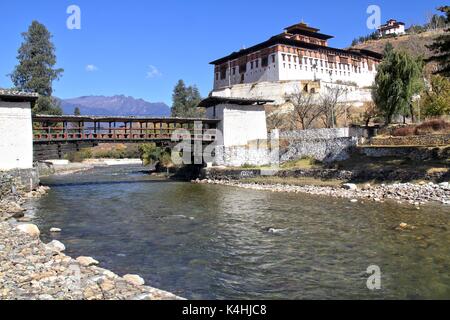 Paro Rinpung Dzong, il tradizionale Bhutan palace con il ponte di legno attraverso il fiume Paro Chu vicino alla città di Paro, Bhutan Foto Stock