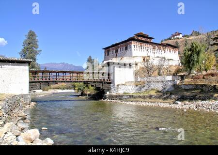 Paro Rinpung Dzong, il tradizionale Bhutan palace con il ponte di legno attraverso il fiume Paro Chu vicino alla città di Paro, Bhutan Foto Stock