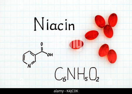 Formula chimica di niacina con la pillola rossa. close-up. Foto Stock