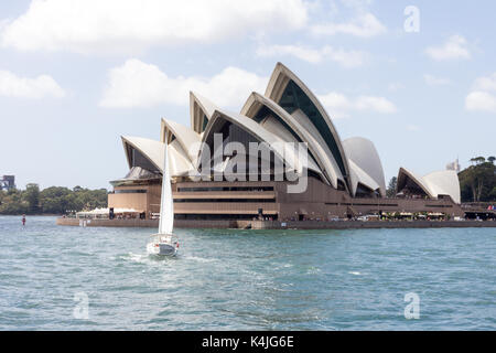 Uno yacht vele passato l'Opera House di Sydney Harbour, Nuovo Galles del Sud, NSW, Australia Foto Stock