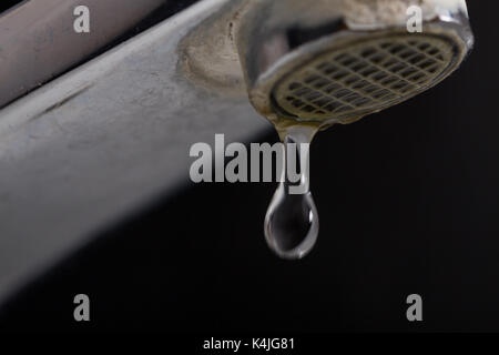 Il vecchio perde il rubinetto con pietra e sedimenti di calcio a causa di acqua dura. Foto Stock