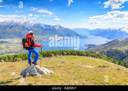 Escursionista sui prati verdi ammira il lago di como circondato da boschi, montemezzo, alpe zocca, Lombardia, laghi italiani, l'Italia, Europa Foto Stock