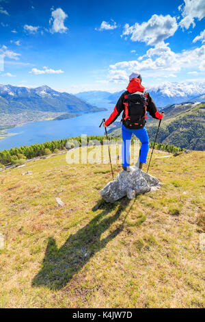 Escursionista sui prati verdi ammira il lago di como circondato da boschi, montemezzo, alpe zocca, Lombardia, laghi italiani, l'Italia, Europa Foto Stock