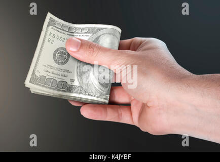 Un maschio di mano di consegnare un batuffolo di ripiegata dollaro americano banconote su un sfondo isolato Foto Stock