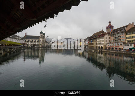 Vista della Chiesa dei Gesuiti e degli edifici tipici dal Ponte della Cappella sul fiume Reuss Rathausquai Lucerna Svizzera Europa Foto Stock