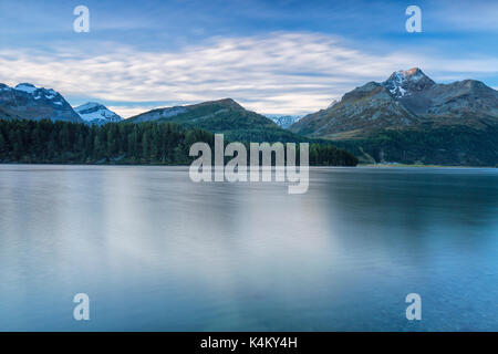 Alba illumina i picchi si riflette nelle calme acque del lago di Sils Engadina Canton Grigioni Svizzera Europa Foto Stock