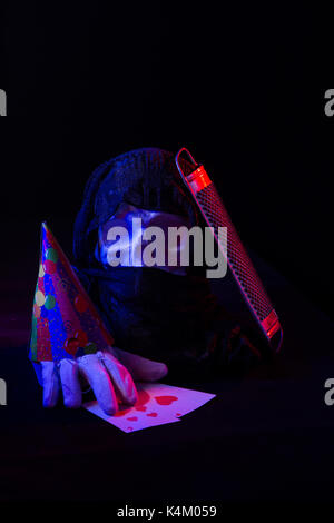 Un colorato ancora la vita di un cranio artificiale e un volto femminile statua. di blu e di rosso le luci in studio e composizione artistica Foto Stock