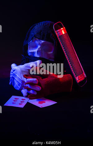 Un colorato ancora la vita di un cranio artificiale e un volto femminile statua. di blu e di rosso le luci in studio e composizione artistica Foto Stock