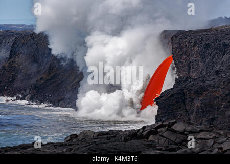 Vista ingrandita del rosso di lava fusa di un vulcano attivo da una cima in Hawaii National Park che scorre come un fuoco flessibile nell'esplosione di ocea Foto Stock