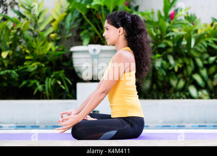 Giovane donna a praticare yoga nella posizione del loto all'aperto Foto Stock