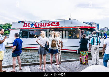 Washington DC, Stati Uniti d'America - 4 Agosto 2017: le persone in piedi in Georgetown parco sul lungofiume in serata con il fiume Potomac e DC barca Crociere Foto Stock