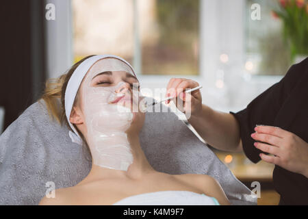 Estetista applicazione peeling anzymatic sul volto di donna in spa Foto Stock