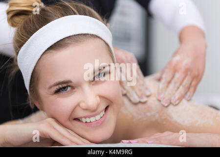 Donna in spa durante scrub al sale di trattamento di bellezza Foto Stock