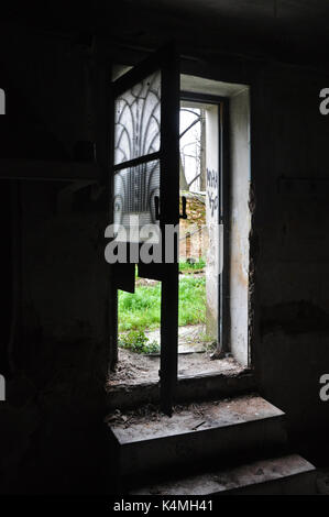 Dark casa abbandonata interno passi di sporco e di luce attraverso lo sportello rotto con mobili antichi di lamiera motif. Foto Stock