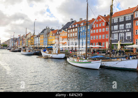 Facciate colorate e tipiche imbarcazioni lungo il canale e dal quartiere degli intrattenimenti di Nyhavn, Copenaghen, Danimarca, Europa Foto Stock