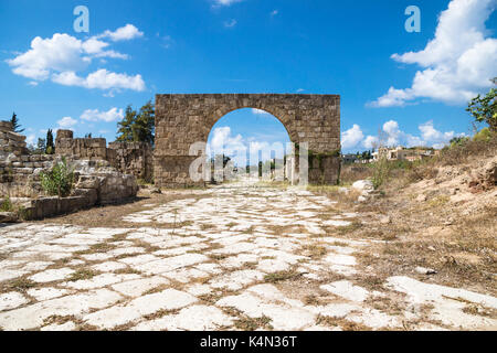 Strada bizantina con arco di trionfo con cielo blu in rovine del pneumatico, Libano Foto Stock