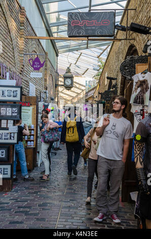 Una trafficata via di passaggio attraverso le scuderie mercato, la parte di mercato di Camden in camden town a Londra. Foto Stock