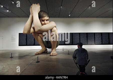 Un uomo guarda al Ron Mueck's Boy a ARoS Aarhus Kunstmuseum ad Aarhus in Danimarca. Foto Stock