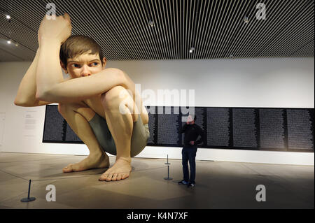 Un uomo guarda al Ron Mueck's Boy a ARoS Aarhus Kunstmuseum ad Aarhus in Danimarca. Foto Stock