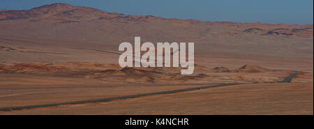 Pan American highway (ruta 5) che corre attraverso il duro e arido paesaggio di Atacama nel nord del Cile. Foto Stock