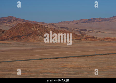 Pan American highway (ruta 5) che corre attraverso il duro e arido paesaggio di Atacama nel nord del Cile. Foto Stock