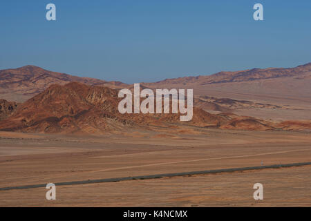 Pan American highway (ruta 5) che corre attraverso il duro e arido paesaggio di Atacama nel nord del Cile. Foto Stock