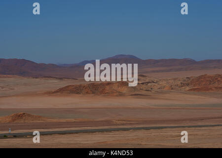 Pan American highway (ruta 5) che corre attraverso il duro e arido paesaggio di Atacama nel nord del Cile. Foto Stock