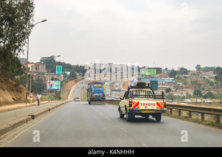 Guida di veicoli su strada a scivolo a Thika autostrada con traffico su autostrada principale come pedoni a piedi sul lato della strada, Nairobi, Kenia Foto Stock