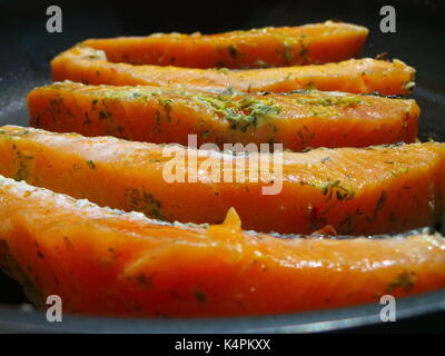 Materie filetto di salmone per friggere in una padella calda Foto Stock