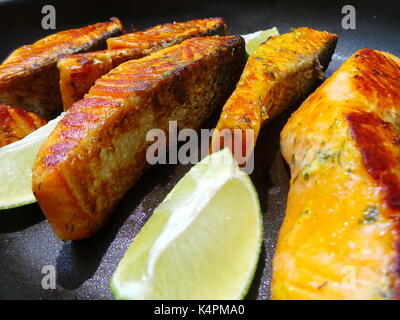 Saporiti filetti di salmone frittura con le fette di limone Foto Stock