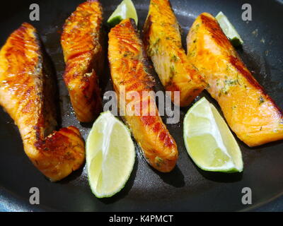 Saporiti filetti di salmone frittura con le fette di limone Foto Stock