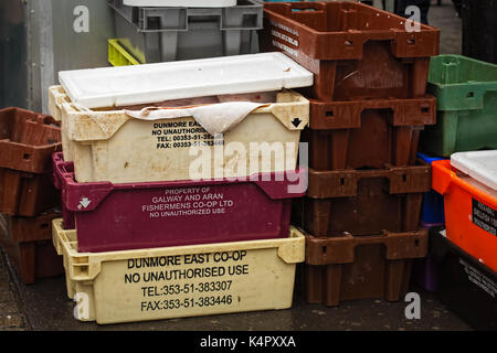 Contenitori con pesce consegna a moore street market al venditore, che spacchettarli e posto in platea per i clienti all'acquisto. Foto Stock