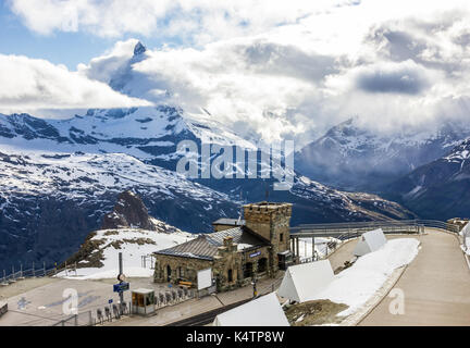 Majestic sognante vista nevoso stazione Gornergrat e il celeberrimo Matterhorn protetto con picco di nuvole, Zermatt, Svizzera, Europa. Foto Stock