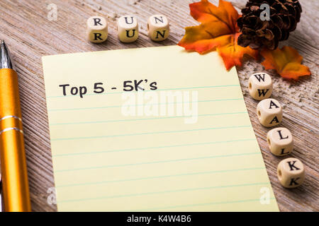 5k correre a piedi concetto su notebook e la tavola di legno Foto Stock